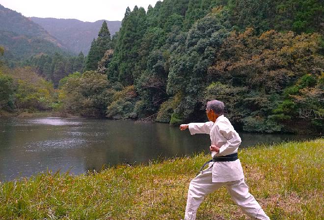 湖のほとりで空手をしている老人。