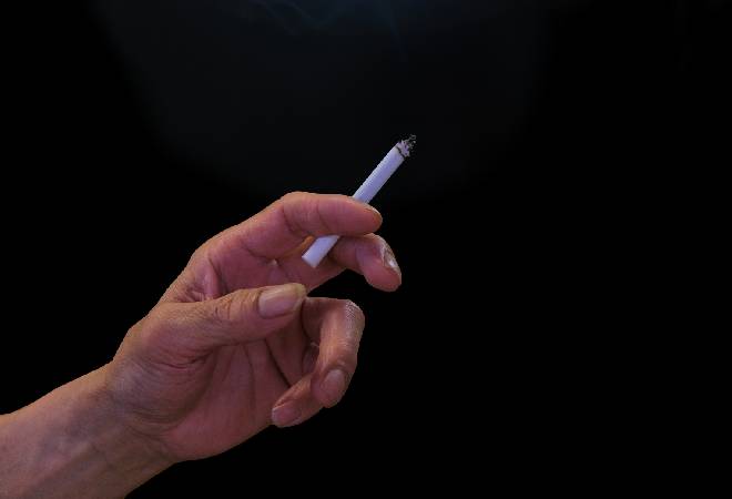 タバコを持つ男性の手。