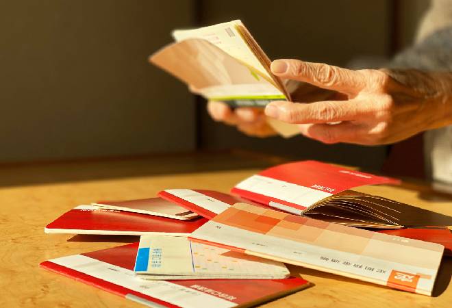 沢山の通帳を広げる高齢者。