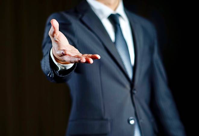 手を差し伸べる怪しいビジネスマンの姿。