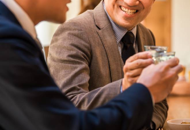 お酒を酌み交わす男性の姿。