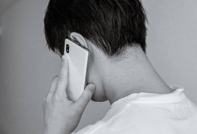 電話する大学生の後ろ姿。