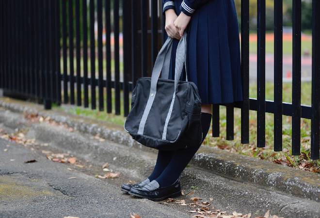 誰かを待っている女子生徒の姿。