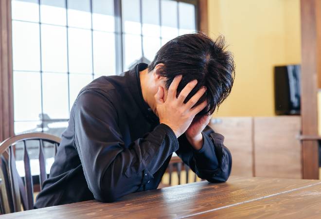 頭を抱える男性。
