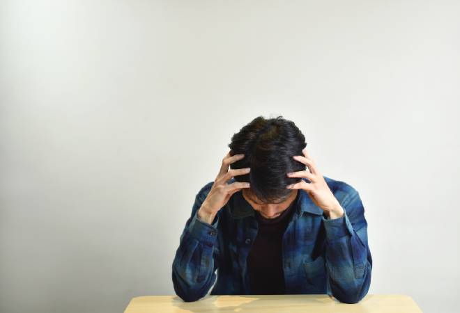 頭を抱える男性の姿。